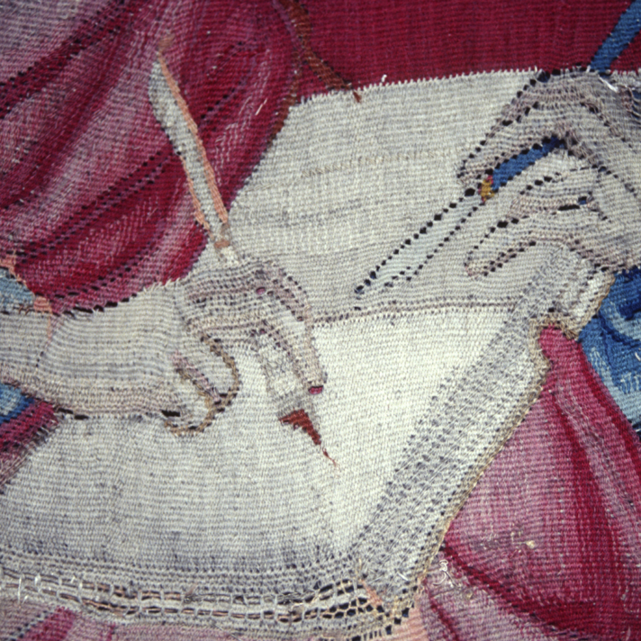 Tapestry of the Apocalypse, detail of Saint John writing with a quill or pen. Scene “The Angel with the Book”. Photograph taken from the reverse side.